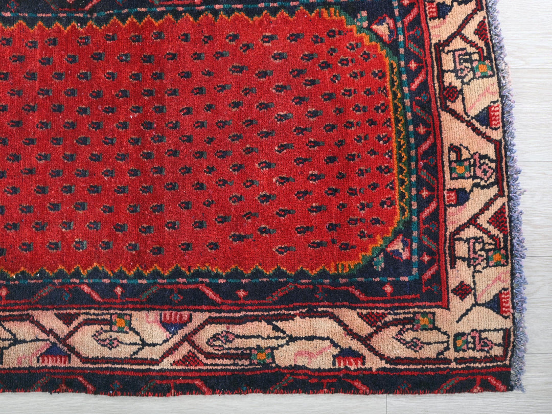 a red and blue rug on a white floor