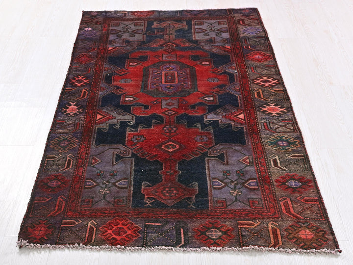 a red and black rug on a white floor