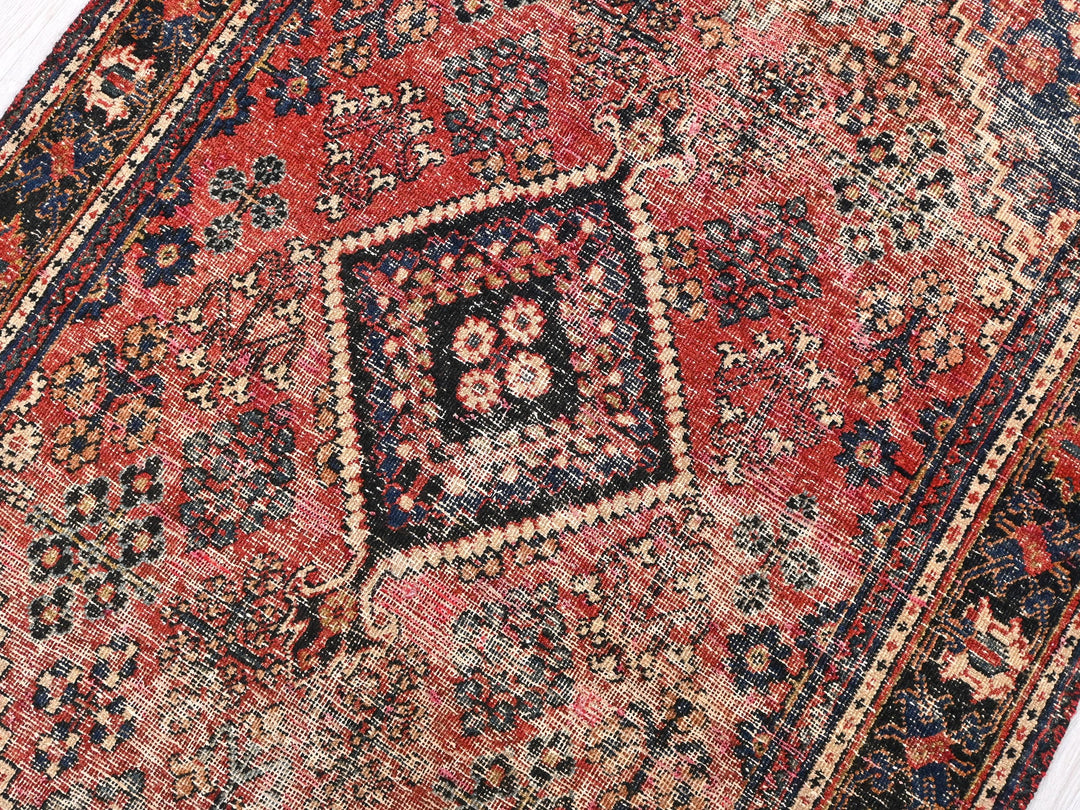 a red rug with a diamond shaped design on it