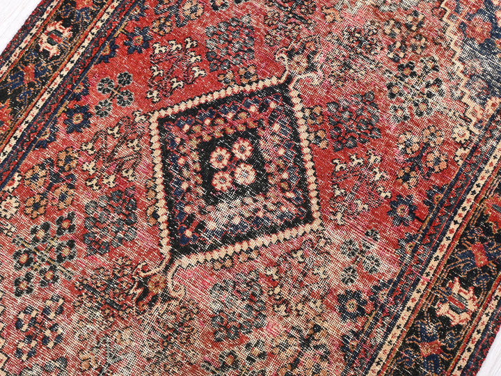a red rug with a diamond shaped design on it