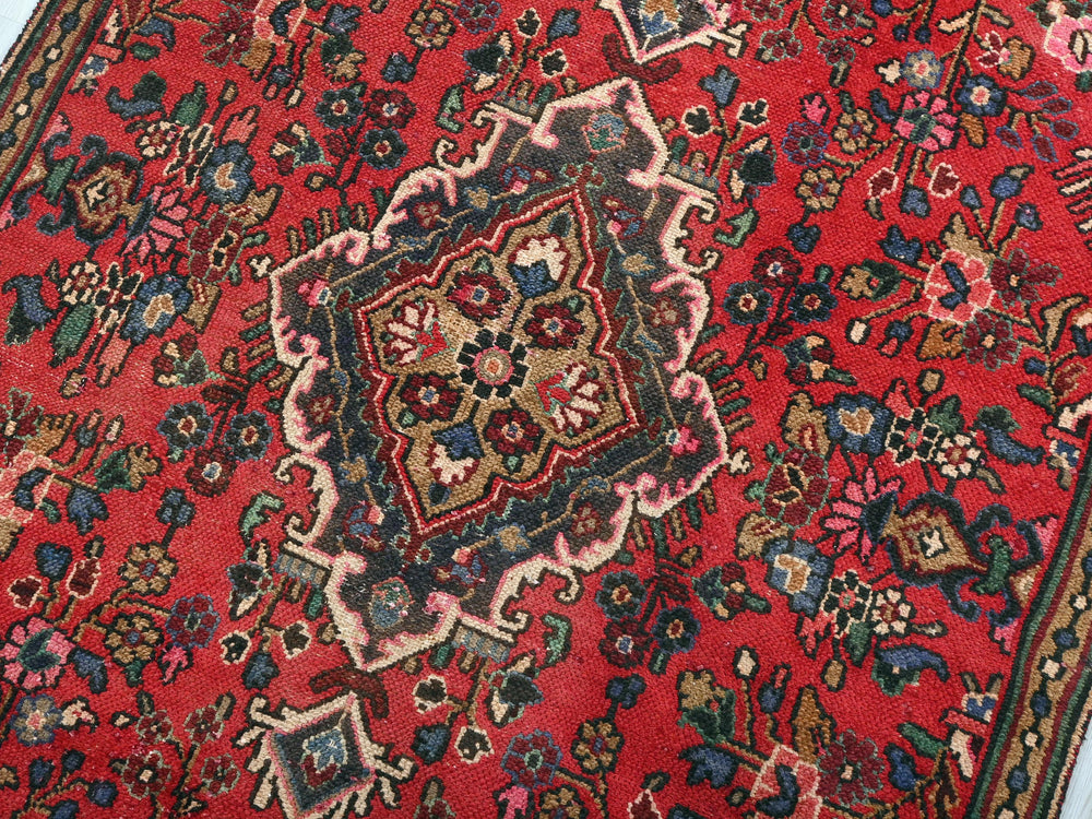 a red rug with a floral design on it