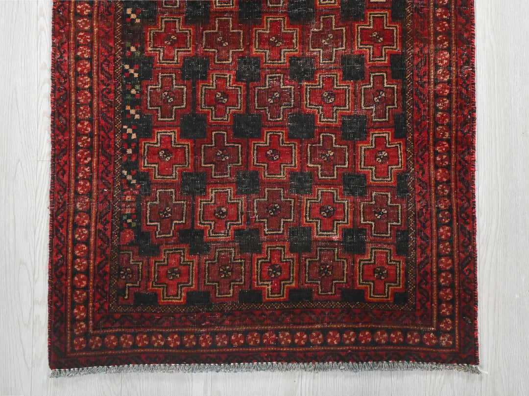 a red and black rug on a white floor