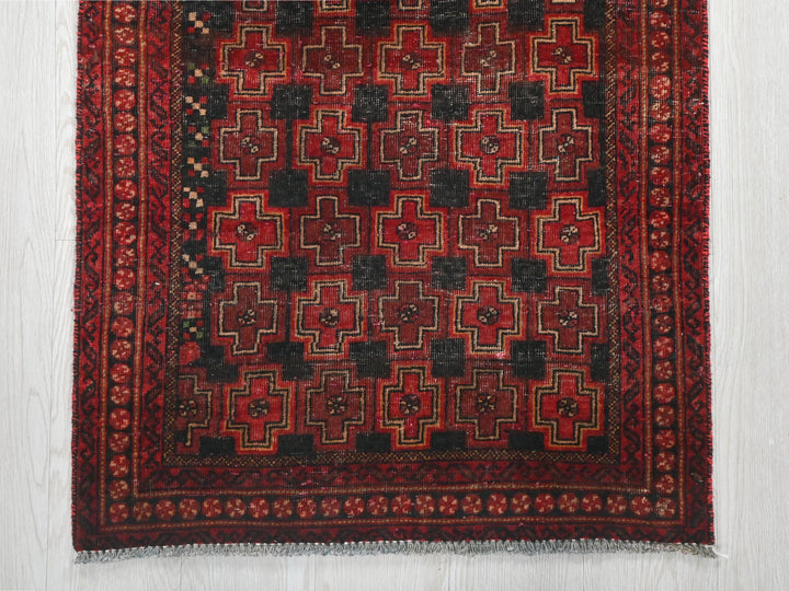 a red and black rug on a white floor