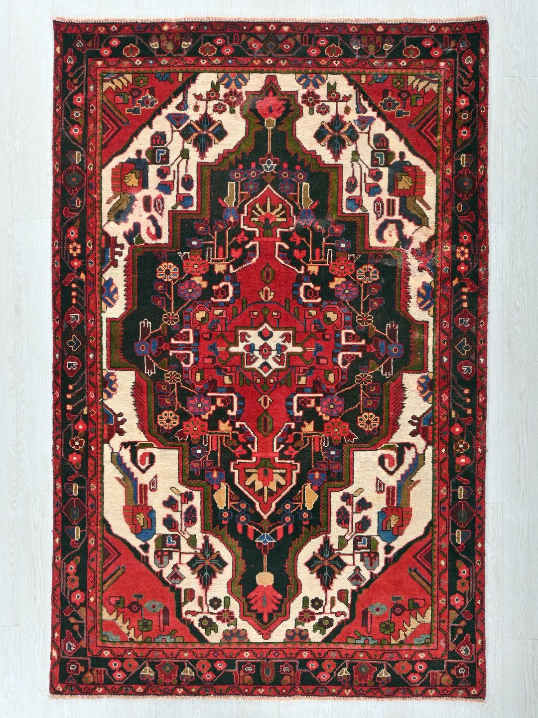 a red and black oriental rug hanging on a wall