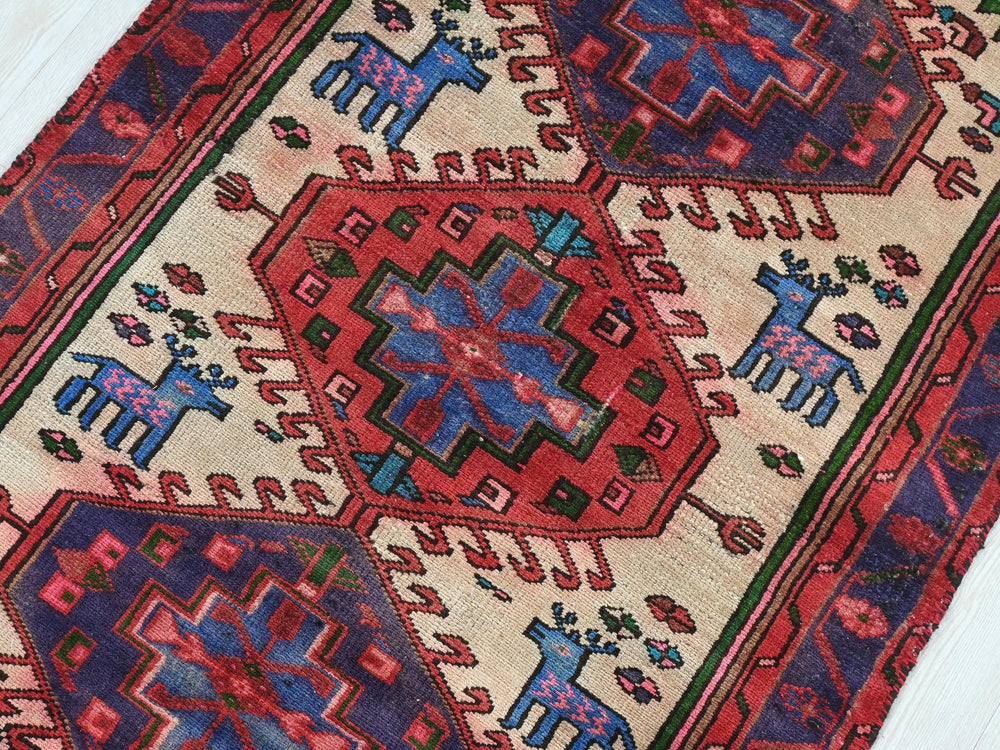 a red and blue rug on a wooden floor