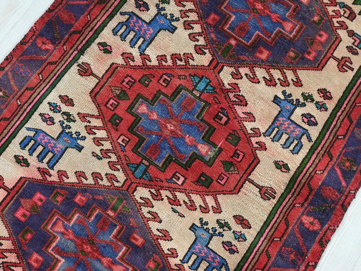 a red and blue rug on a wooden floor