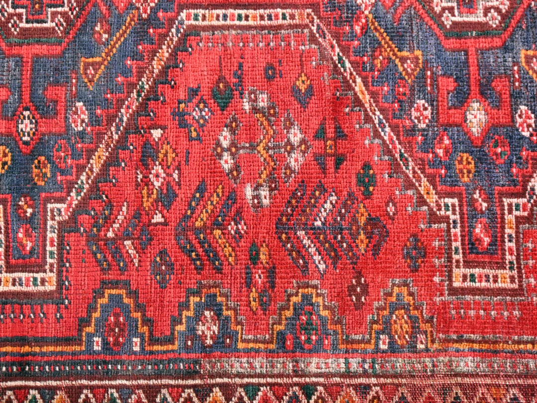 a red rug with many different designs on it
