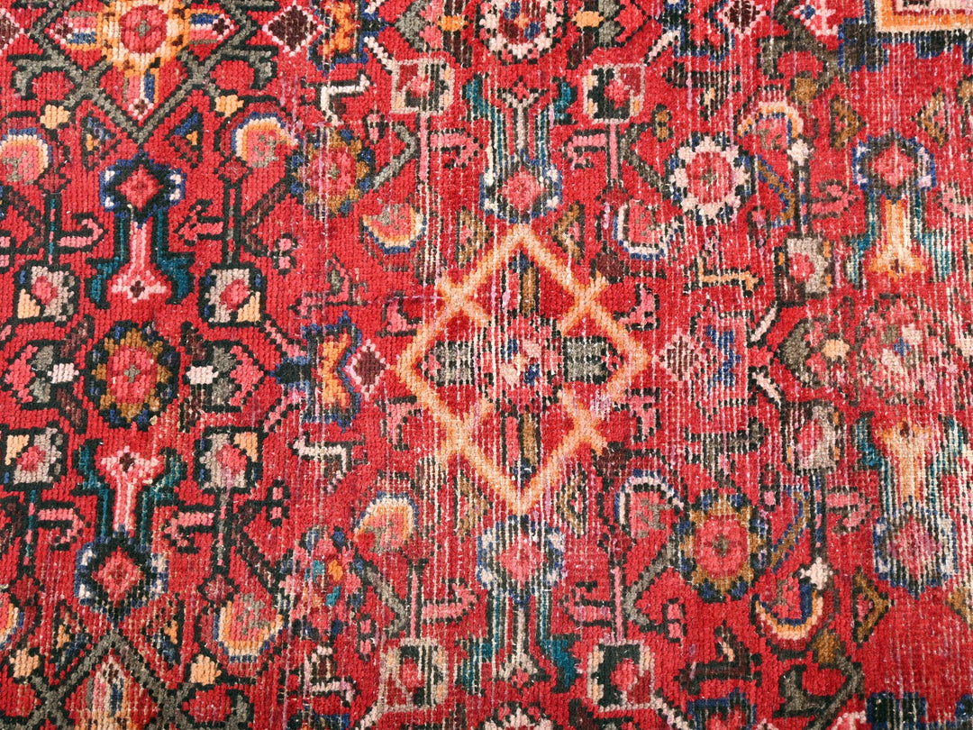 a red rug with a diamond design on it