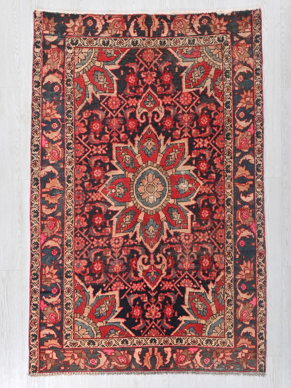 a red and black rug with a floral design