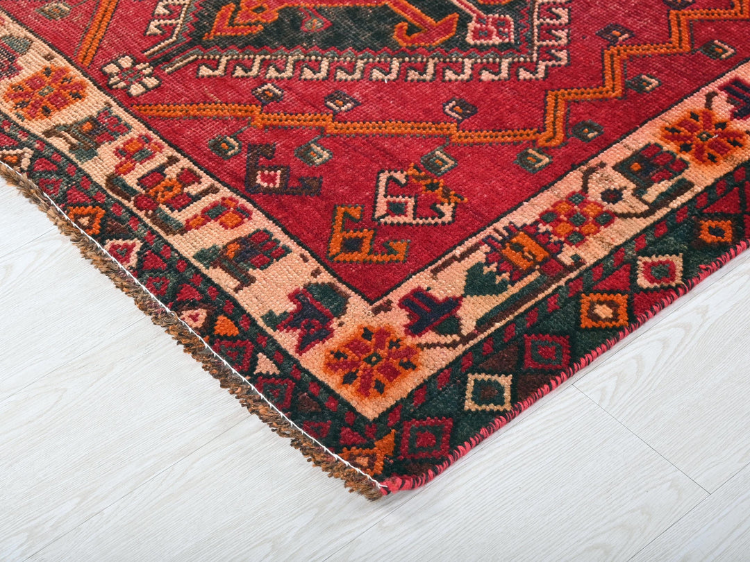 a red oriental rug on a white floor