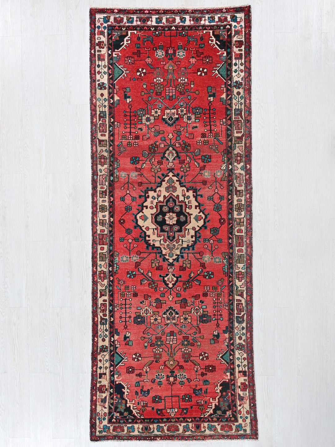 a red oriental rug hanging on a wall
