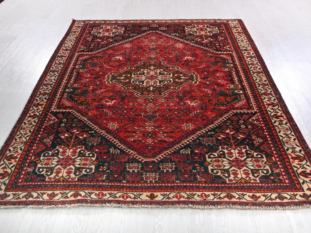 a red and black rug on a white floor