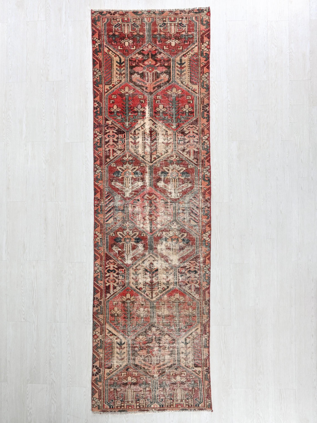 a red rug hanging on a white wall