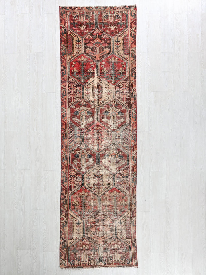 a red rug hanging on a white wall