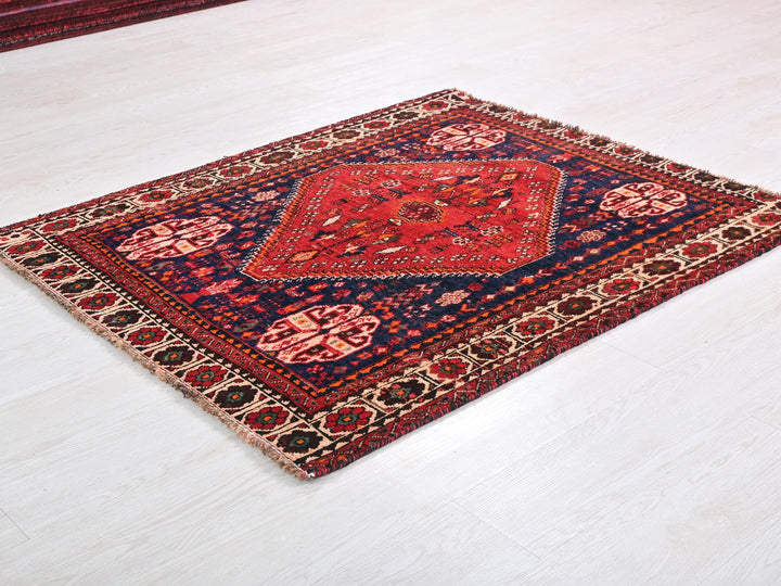 a red and blue rug on a white floor