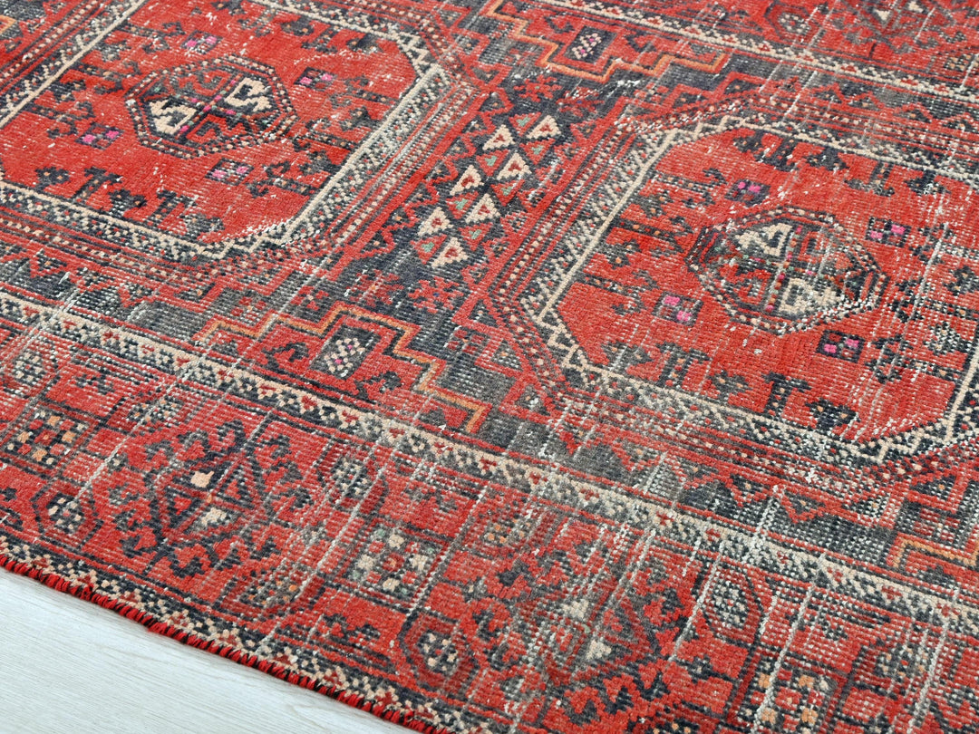 a red rug with a blue and white design on it