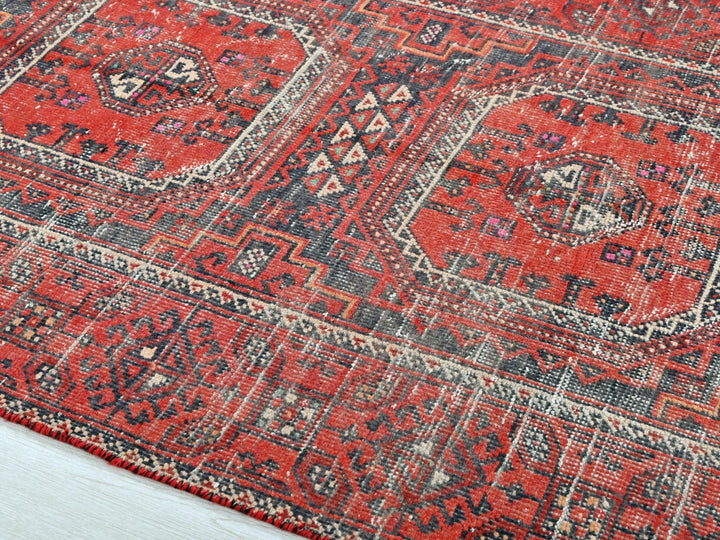a red rug with a blue and white design on it