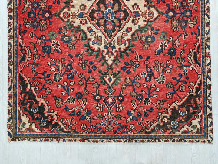 a red rug with a floral design on it