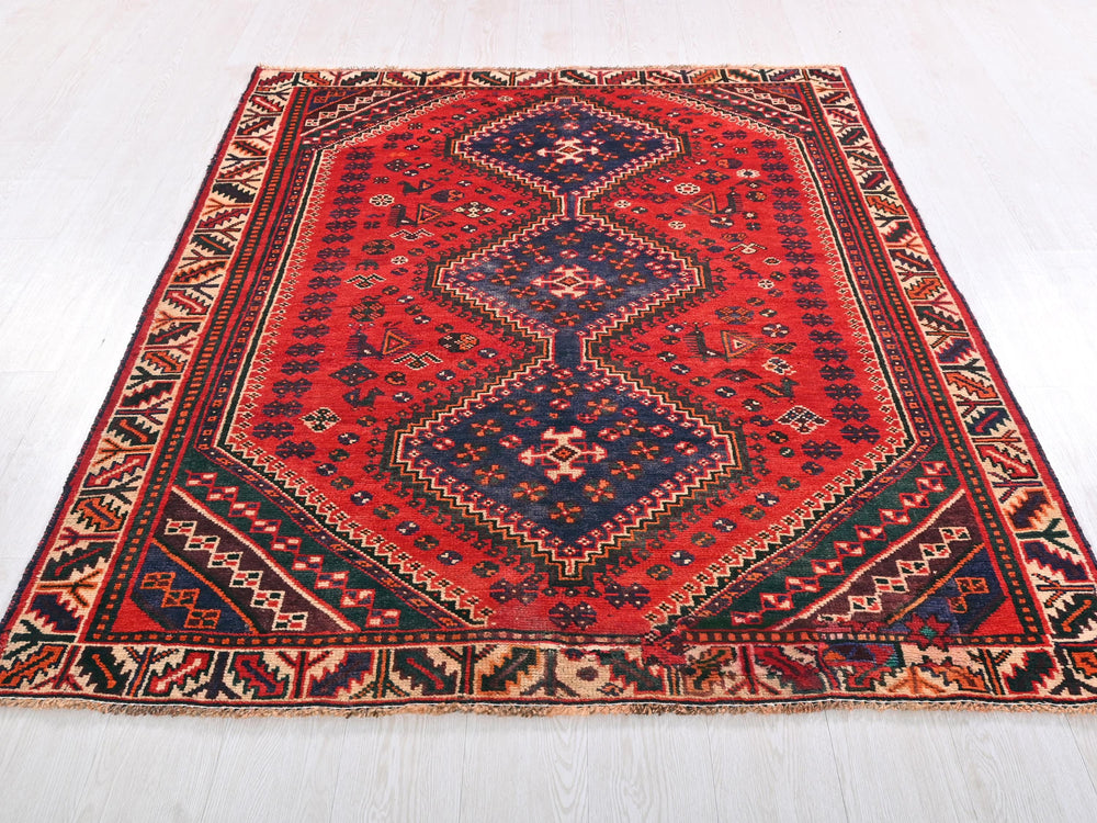 a red and blue rug on a white floor