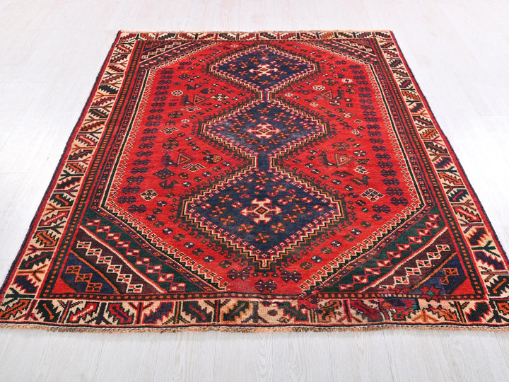 a red and blue rug on a white floor