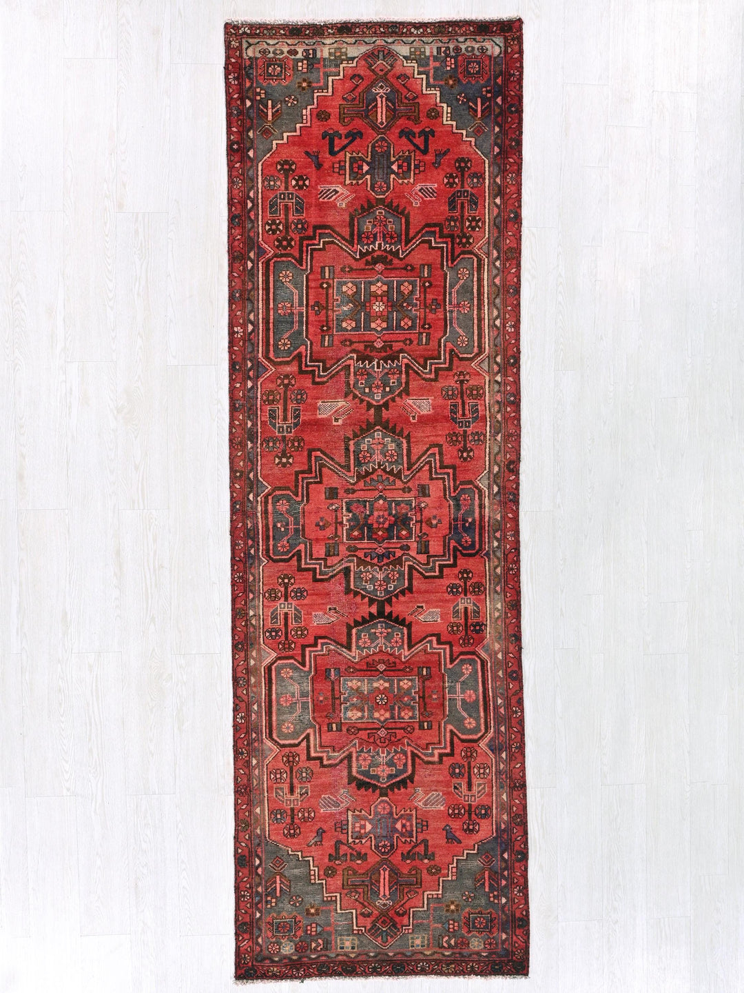 a red oriental rug hanging on a wall