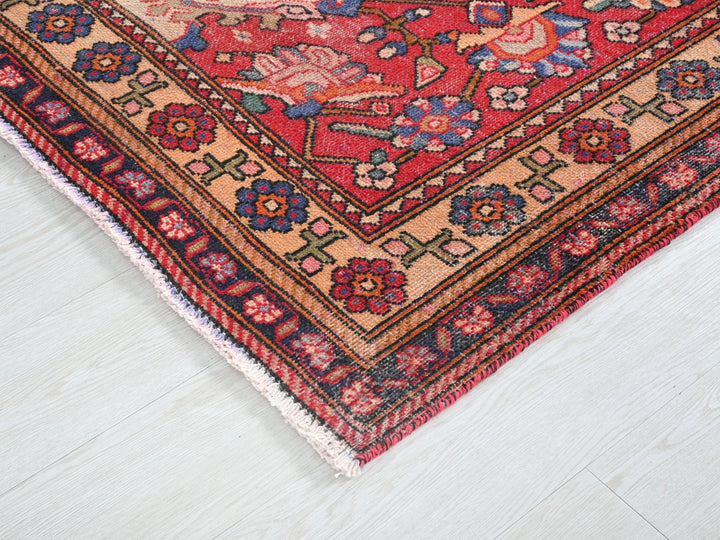 a red rug with a floral design on a white floor
