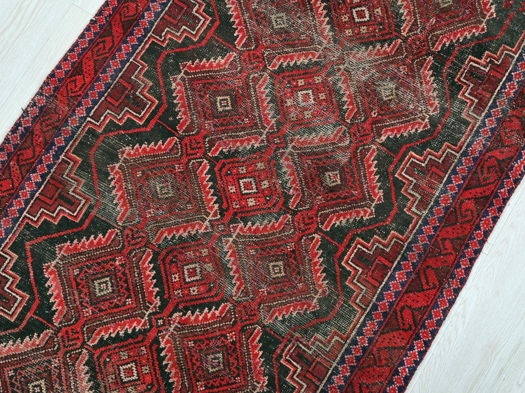 a red and black rug on a white floor