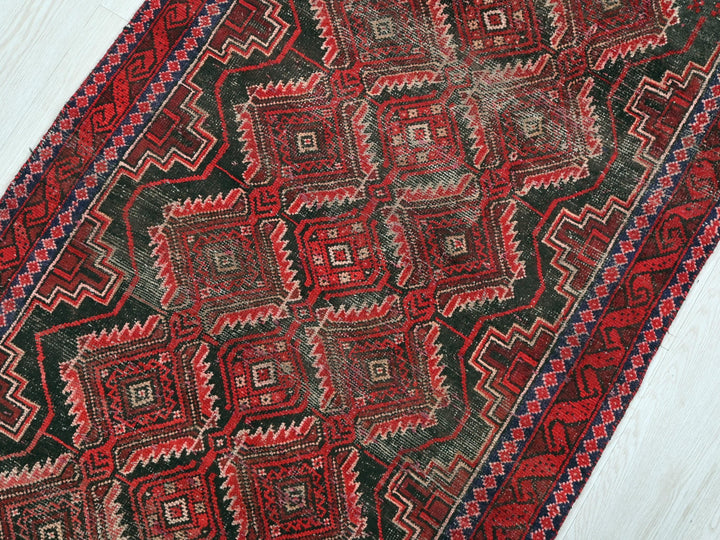 a red and black rug on a white floor
