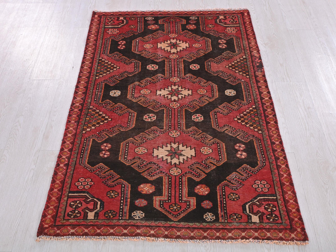 a red and black rug on a white floor