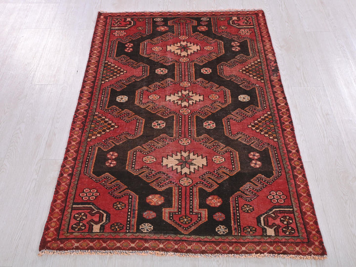 a red and black rug on a white floor