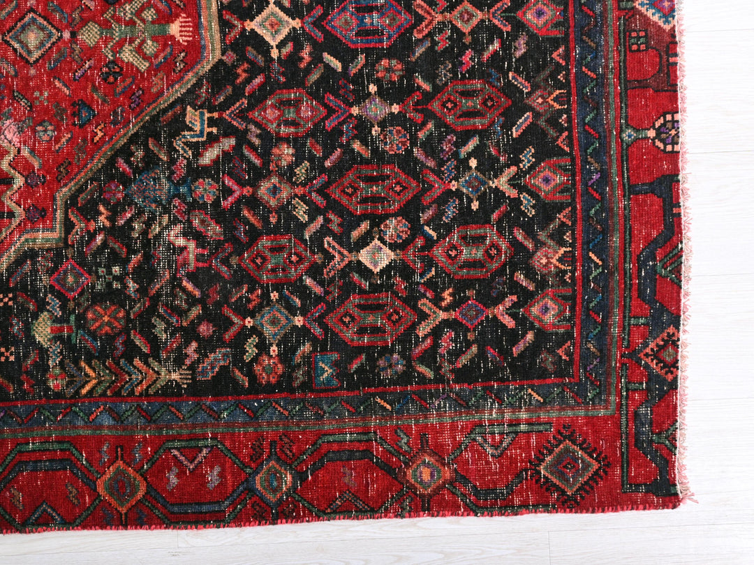 a red and black rug on a white floor