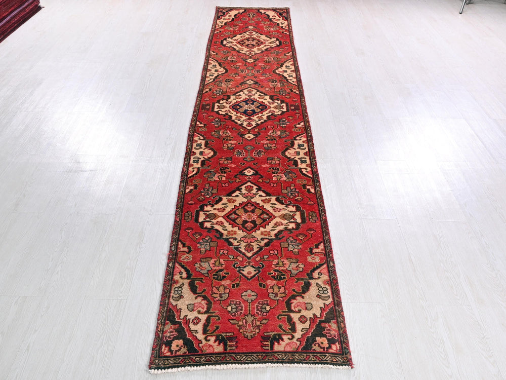 a long red rug on a white floor