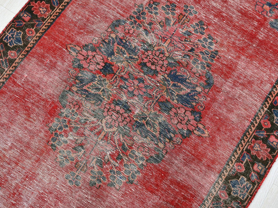 a red area rug with a floral design on it