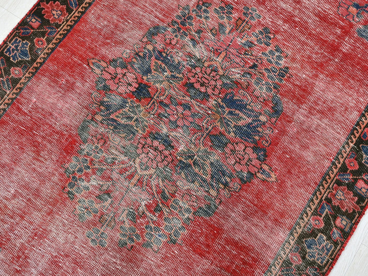 a red area rug with a floral design on it
