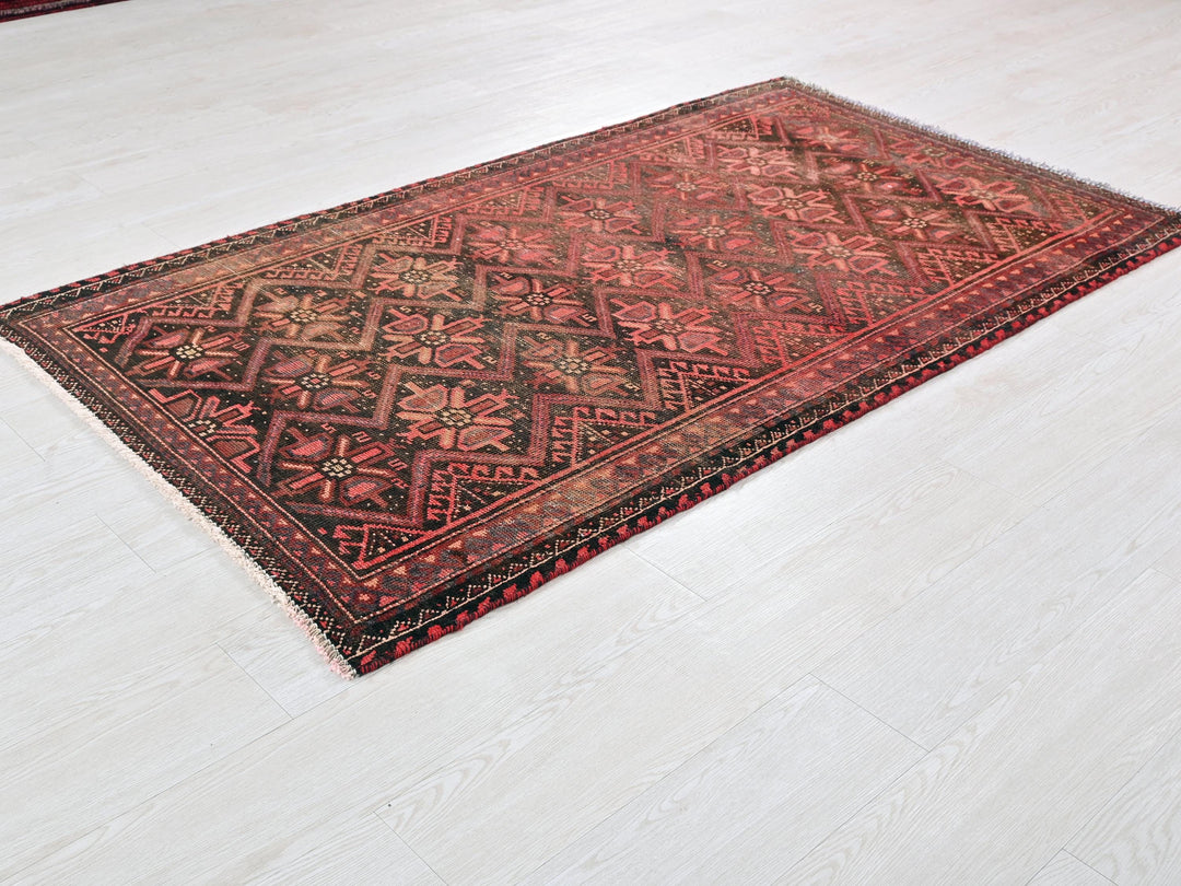 a red and black rug on a white floor