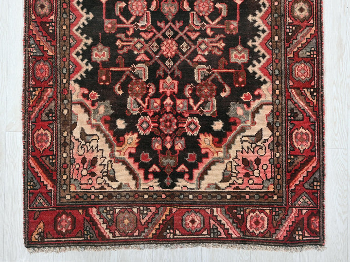 a red and black rug on a white wall
