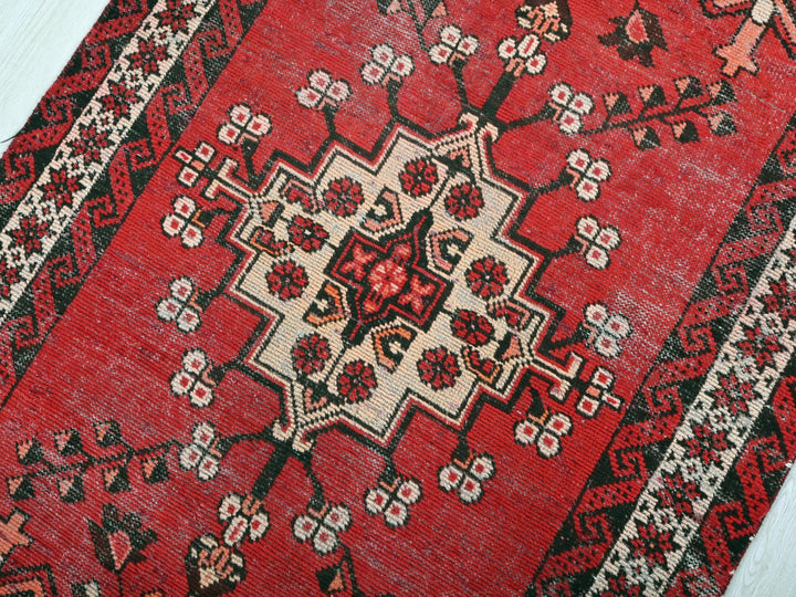 a red rug on a white wooden floor