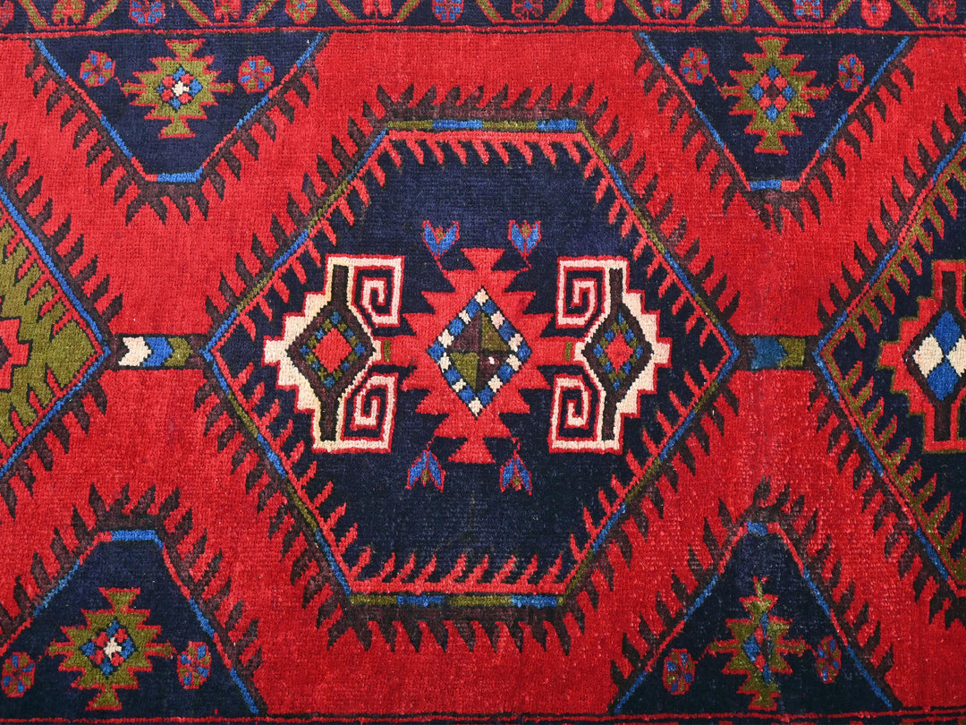 a red, blue, and green rug with a diamond pattern