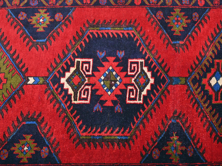 a red, blue, and green rug with a diamond pattern