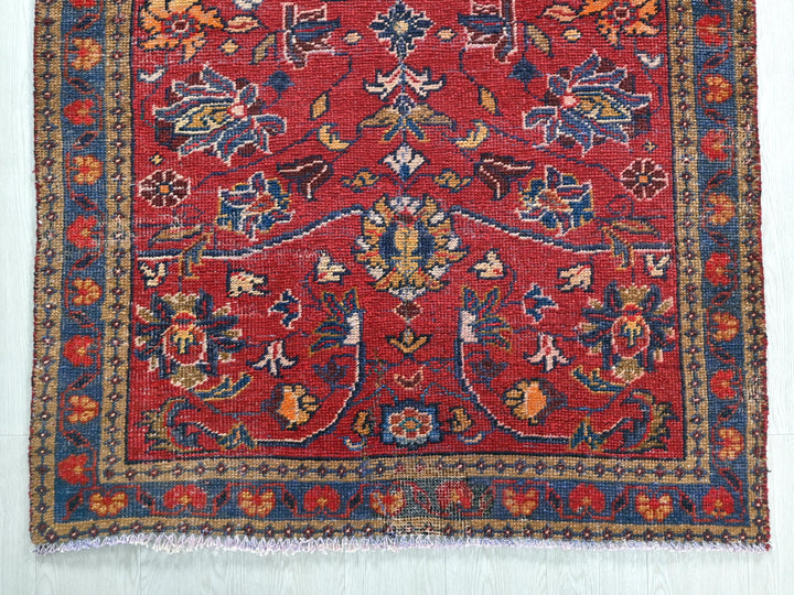 a red rug with a floral design on it