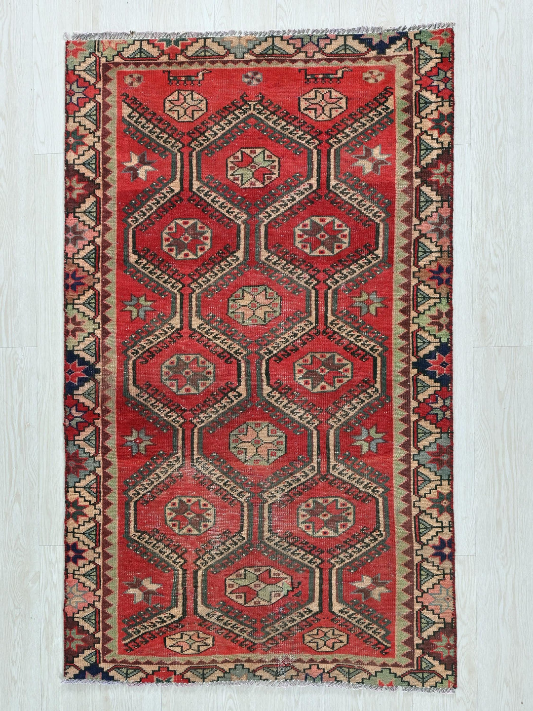 a red rug with a design on the middle of it