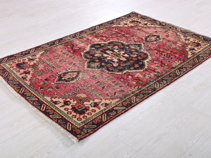 a red and black rug on a white floor