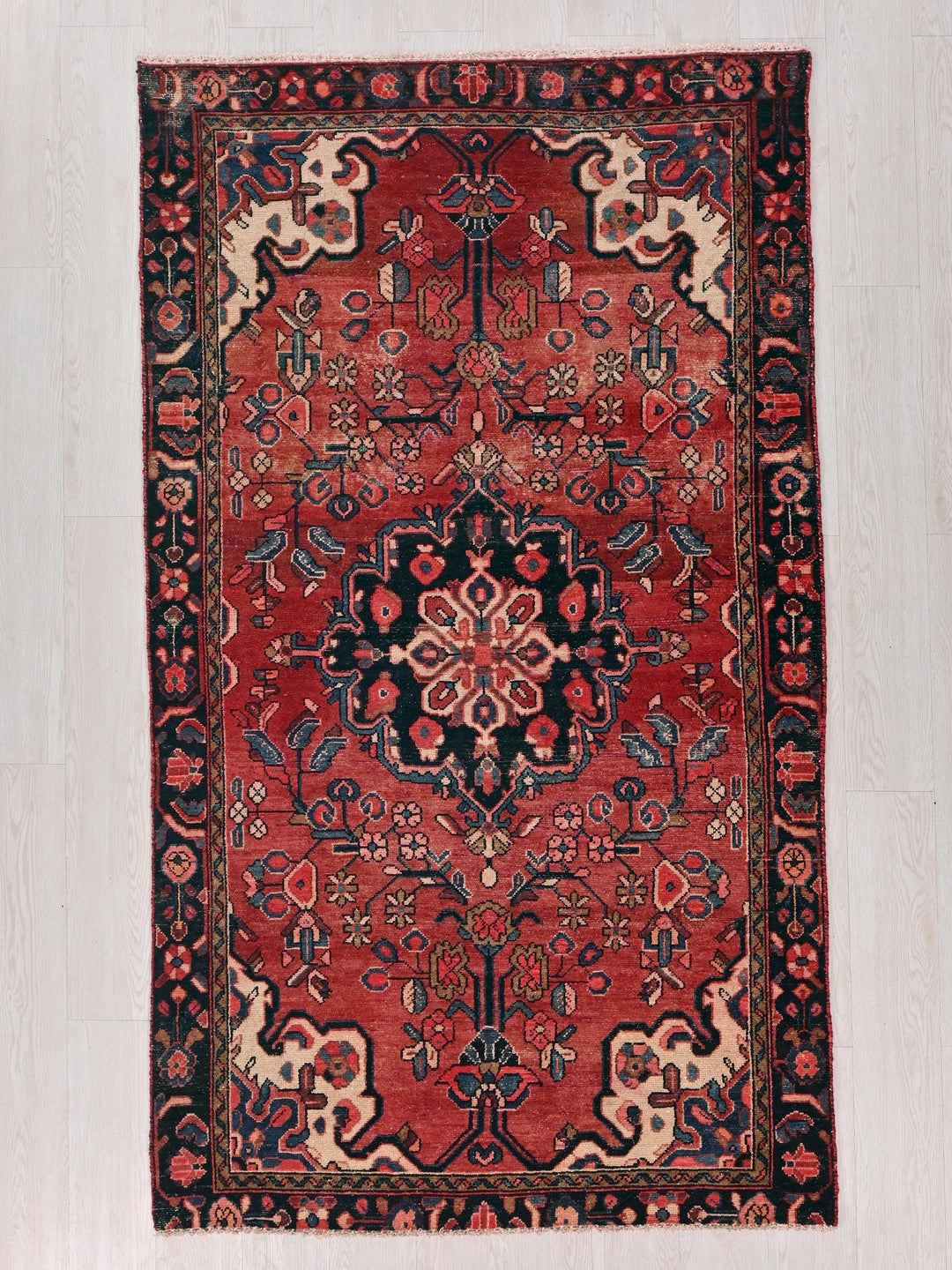 a red and black rug on a white floor