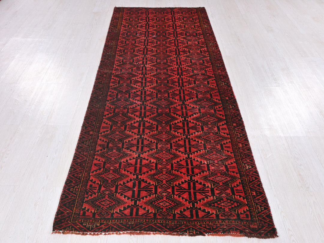 a red and black rug on a white floor