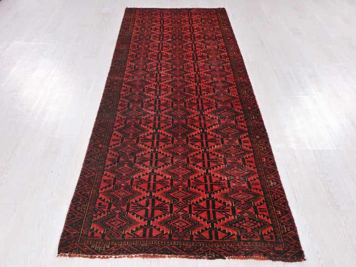 a red and black rug on a white floor