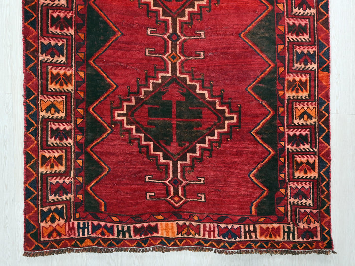 a red rug with a design on it