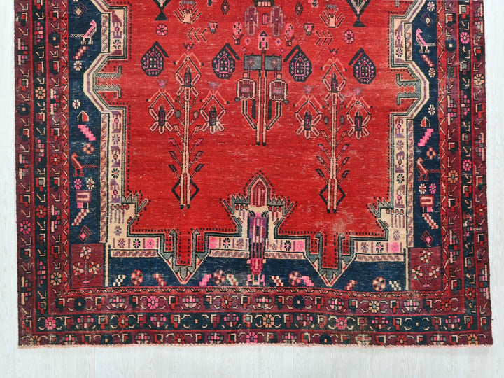 a red rug with a blue border on a white wall