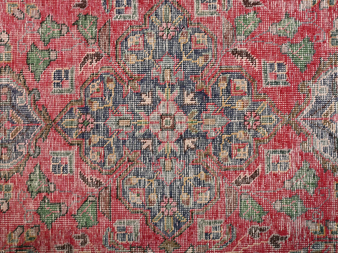 a red rug with a floral design on it