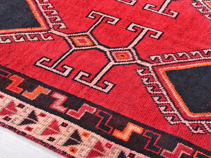 a close up of a red rug on a white floor