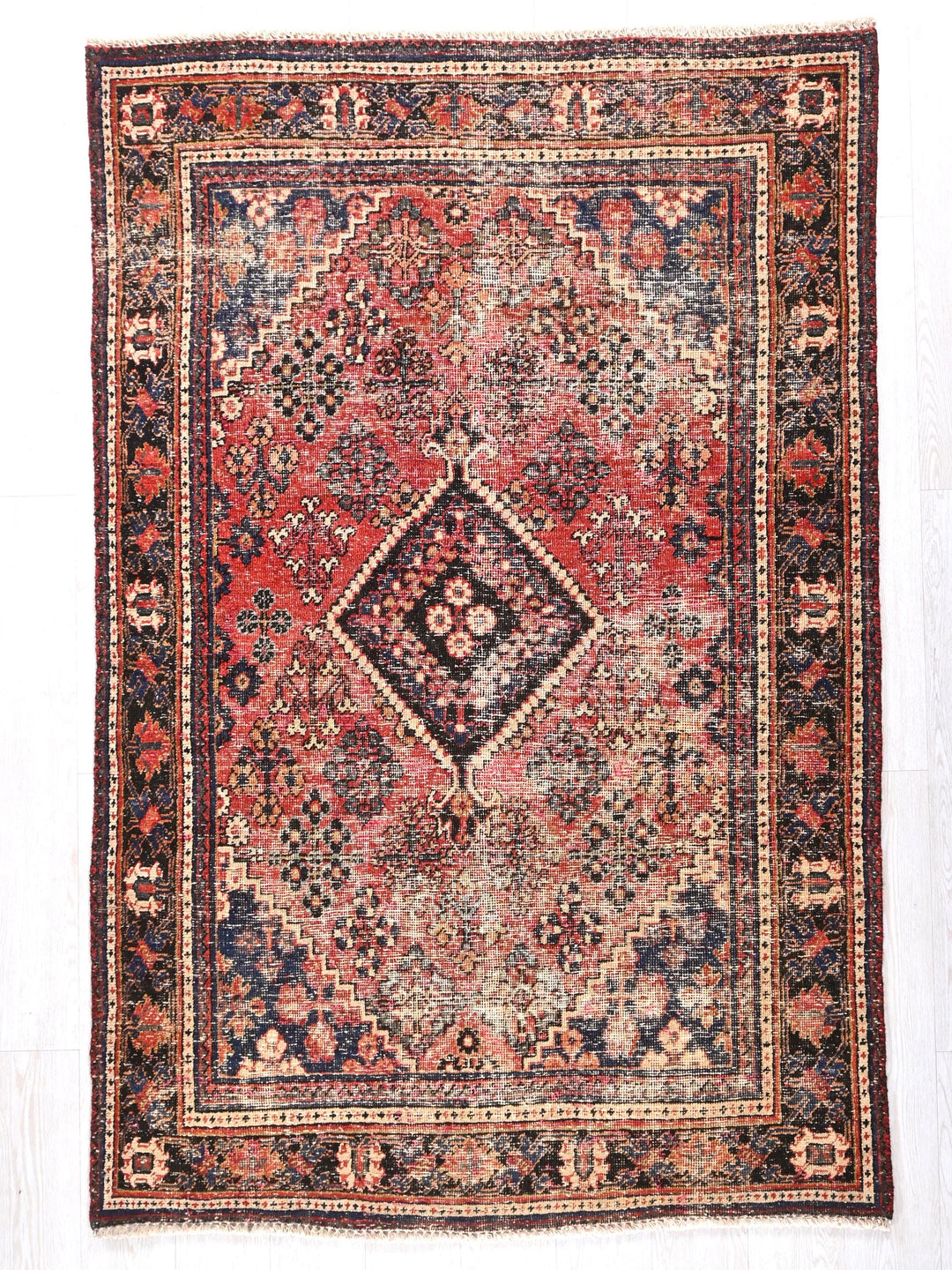 a red and black rug on a white background